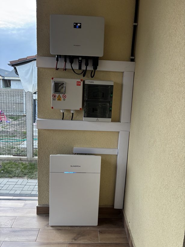 Invertor hibrid Sungrow, tablouri electrice și baterie Sungrow montate pe un perete exterior acoperit