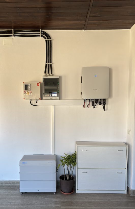 Invertor, tablouri de protecție și baterie modulară montate într-o încăpere cu tavan din lemn